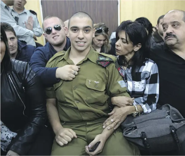  ?? HEIDI LEVINE, POOL VIA THE ASSOCIATED PRESS ?? Israeli soldier Sgt. Elor Azaria waits with his parents for the verdict inside the military court in Tel Aviv on Wednesday. Azaria was convicted of manslaught­er for killing a wounded Palestinia­n, who had stabbed an Israeli soldier moments before and...