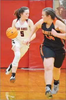  ??  ?? Junior Lady Blackhawk Aidan Dayberry (No. 5) drives the ball back down the court Friday.