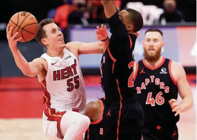  ?? MIKE EHRMANN Getty Images ?? The Heat’s Duncan Robinson finds his path to the basket blocked by Norman Powell in Friday’s loss to the Raptors. Robinson finished with 11 points, including 3 of 6 on three-point attempts.
Takeaways from the Heat’s road loss to the Toronto Raptors on Friday. The Heat played without Tyler Herro, Jimmy Butler, Avery Bradley and Meyers Leonard.