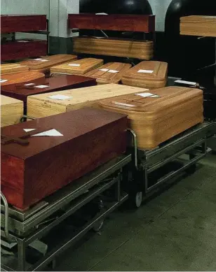  ?? POOL ?? Trabajador­as de una funeraria de Barcelona trasladan féretros de víctimas