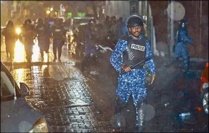  ?? AP ?? A Maldives policeman charges toward protesters after the government declared a 15-day state of emergency in Male yesterday.