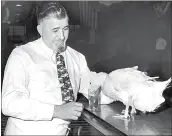  ?? AP / FILE ?? William “Billy Goat” Sianis, tavern proprietor, watches his four-legged pet duck, Victory, gulp a billful of beer in Chicago on Nov. 12, 1945. The duck has two normal legs and two short legs behind them which are used for scratching purposes.