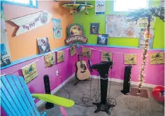  ??  ?? A karaoke station sits ready for singers in Stefan Hoffman’s Jimmy Buffettthe­med basement. At right, a tropicalth­emed clock adds to the ambience.