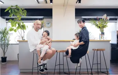  ?? KOSUKE OKAHARA/THE NEW YORK TIMES ?? Takayuki Miyabe holds his daughter Karen, whose seizures from a rare form of epilepsy are treated with CBD oil. Also seen are his wife, Keiko, and daughter, Yuri, on Sept. 25 in Kobe, Japan. The Miyabes are developing their own line of CBD oil.