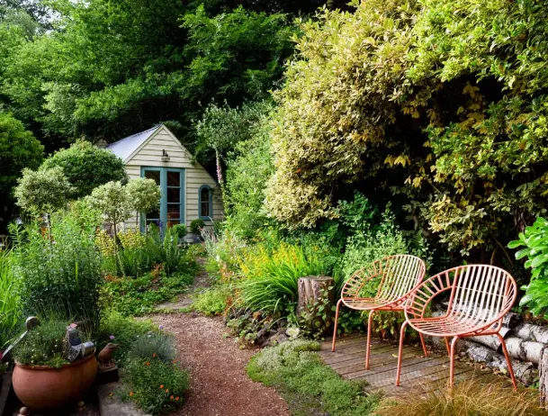  ??  ?? OPPOSITE, FROM LEFT Beside a brick and stone outhouse, campanulas and ferns have self-seeded between paving; a collection of rusty tools is displayed on the fence THIS PAGE, CLOCKWISE FROM TOP The architect’s garden studio is surrounded by creeping thymes and rock roses; pots of succulents are arranged with found bricks; owner Jennifer Lewin