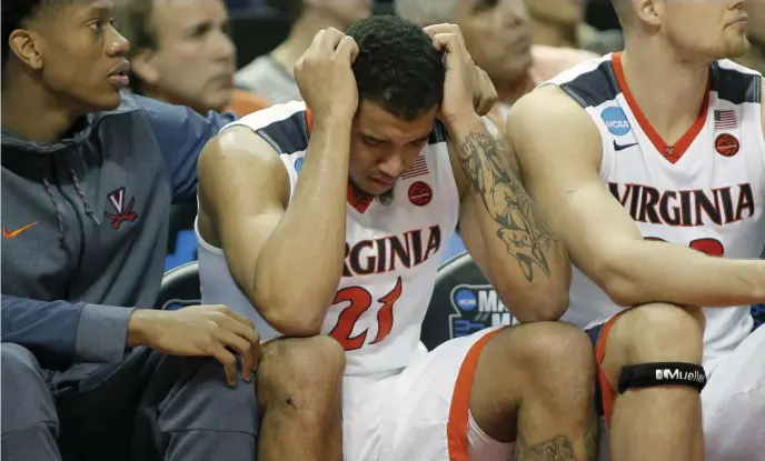  ?? AP FILE ?? STUNNER: Virginia's Isaiah Wilkins (21) is consoled after fouling out during the second half of the team's first-round game against UMBC in the NCAA men's college basketball tournament in Charlotte, N.C. in 2018.