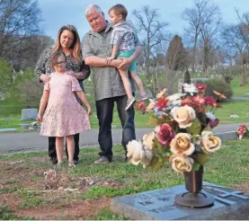 ?? LACY ATKINS/USA TODAY NETWORK ?? Tina and Mickey Baltz visit their daughter Heather’s grave with their grandchild­ren, Braelyn and Tyler, at Calvary Cemetery in Nashville, Tenn. Heather, 28, died after struggling with a heroin addiction.