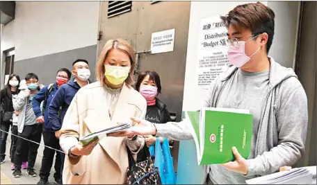  ?? PROVIDED TO CHINA DAILY ?? Hong Kong residents on Wednesday line up at a stand in Wan Chai to get hard copies of the budget speech.