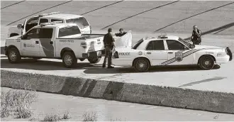  ?? Herika Martinez / AFP / Getty Images ?? Police officers and Border Patrol agents remain near the corpse of a Guatemalan migrant in El Paso on Tuesday. Four Guatemalan migrants died as they tried to cross the Rio Grande.