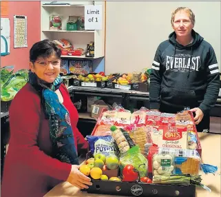  ??  ?? BUSY: Ararat Neighbourh­ood House Food Hub manager Lou Makin and volunteer co-ordinator Dean Pattison with some of the food being distribute­d to needy people.