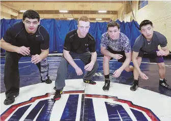  ?? STAFF PHOTO BY NICOLAUS CZARNECKI ?? READY TO ROCK: Boston Latin wrestlers, from left, Zachary Taieb, Will Jerome, Aidan Kilgannon and Nelson Wu pose prior to a practice at the school on Monday.