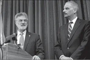  ?? AP/TONY DEJAK ?? U. S. Attorney General Eric Holder (right) listens as Cleveland Mayor Frank Jackson speaks at a news conference Thursday in Cleveland.