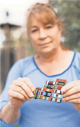  ??  ?? The Guard was “everything to me,” says Teresa James, displaying the ribbon bars she earned in the West Virginia Army National Guard. She says she was punished after accusing a superior officer of rape. THE HORNES PHOTOGRAPH­Y