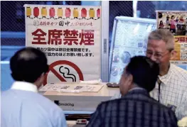  ?? The Yomiuri Shimbun ?? A sign indicating that all seats are non-smoking is seen on the window of a restaurant in Tokyo’s Chiyoda Ward in June 2018.