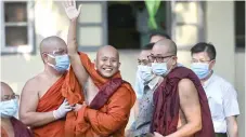  ?? — AFP photo ?? Wirathu (second left) waves to his followers before turning himself in at a Yangon police station.