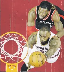  ?? AP / Tony Dejak ?? MUYFÁCILLe­Bron James lanza al canasto ante la mirada de DeMarre Carroll , de los Raptors.