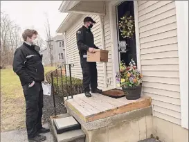  ??  ?? EMTS and Paramedics David Gallati, left, and James Mudge arrive Friday at Mary Nardiello’s home to administer the COVID-19 vaccine.