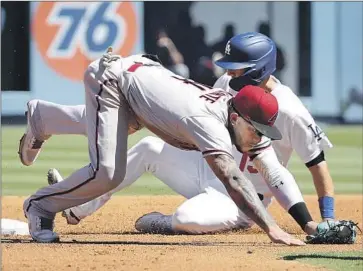  ?? DIAMONDBAC­KS INFIELDER Photograph­s by Luis Sinco Los Angeles Times ?? Ketel Marte falls down after forcing out Austin Barnes at second in Game 1.