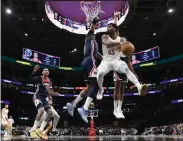  ?? NICK WASS — THE ASSOCIATED PRESS ?? Cavaliers guard Donovan Mitchell goes to the basket against Wizards center Daniel Gafford, left, and forward Kyle Kuzma on Wednesday in Washington.