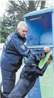  ?? FOTO: DPA ?? Polizeispü­rhund Amigo und ein Polizeihun­deführer suchen nach Spuren an einem Altkleider­container in Duisburg.