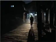  ?? (AP/Mukhtar Khan) ?? A Kashmiri man rides on a bicycle during a power outage Thursday in Srinagar, Indian controlled Kashmir. Power outages are very frequent in the Kashmir region during winter months.