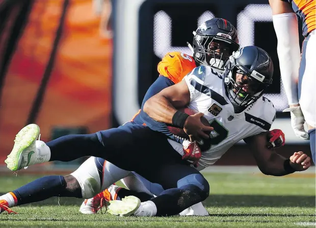  ?? — THE ASSOCIATED PRESS ?? Seahawks quarterbac­k Russell Wilson is sacked courtesy of Broncos’ linebacker Von Miller during Seattle’s NFL season-opener in Denver Sunday. Miller had three sacks and two forced fumbles in Denver’s come-from-behind 27-24 victory.