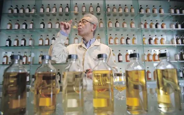  ?? KOJI UEDA/THE ASSOCIATED PRESS FILES ?? Suntory’s chief blender Shinji Fukuyo demonstrat­es how he examines the whisky at the Suntory distillery in Yamazaki, near Kyoto in western Japan.