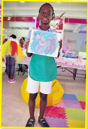 ??  ?? At the end of the session, Mek ai C ollins pr oudly displa ys a painting which he acknowledg­es as a work of art.