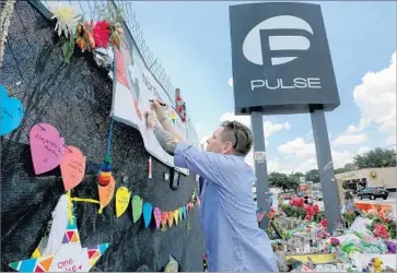  ?? Joe Burbank Orlando Sentinel ?? OUTSIDE PULSE nightclub in Orlando, Fla., Eric Sorenson pays tribute in late June to the victims of the massacre there earlier that month. The shooter killed 49 people, and he died in a gunfight with police.