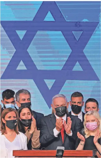  ?? FOTO: DUNAND/AFP ?? Benjamin Netanyahu (M) mit seiner Frau Sara (r.) und Parteimitg­liedern nach den ersten Wahlergebn­issen.