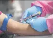  ?? JOHN RAOUX — THE ASSOCIATED PRESS FILE ?? On May 5, a health worker draws blood from a patient for a COVID-19 coronaviru­s antibody test in DeLand, Fla. Scientists are still working to figure out how well antibodies for the new coronaviru­s may shield someone from another infection, or how long that protection might last.