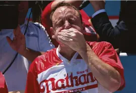  ??  ?? ABOVE Joey Chestnut defends his title at 2019’s Nathan’s Famous Internatio­nal Hot Dog Eating Contest