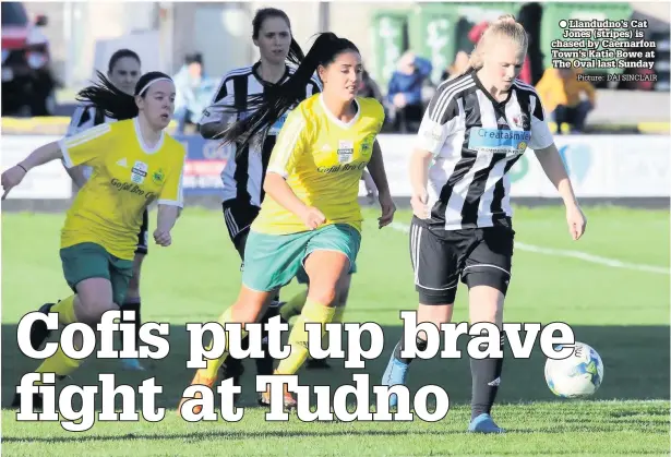  ??  ?? ● Llandudno’s Cat Jones (stripes) is chased by Caernarfon Town’s Katie Bowe at The Oval last Sunday