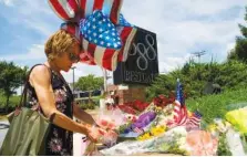  ?? AP PHOTO BY JOSE LUIS MAGANA ?? Elly M. Tierney places flowers Friday at a makeshift memorial at the scene outside the office building housing The Capital newspaper in Annapolis, Md.