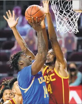  ?? Mark J. Terrill Associated Press ?? UCLA’S KENNETH NWUBA, left, shoots over USC’s Evan Mobley during the first half. Nwuba was held scoreless in 12 minutes of the 66-48 loss to the Trojans.