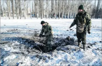  ?? PICTURE: ASSOCIATED PRESS ?? Ukrainian soldiers inspect a crater left by an explosion in Avdiivka, Ukraine. Fighting between government troops and Russian-backed separatist rebels in eastern Ukraine escalated yesterday, killing at least eight people, injuring dozens.