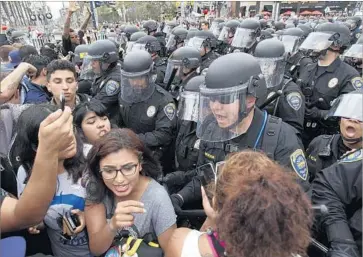  ?? Hayne Palmour IV San Diego Union-Tribune ?? POLICE ATTEMPT to move a crowd of anti-Trump protesters outside a campaign rally for then-presidenti­al candidate Donald Trump at the San Diego Convention Center in 2016. Officers declared an unlawful assembly.