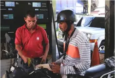  ??  ?? A gas station worker pumps gas into a motorbike at a gas station of the Venezuelan state-owned oil company PDVSA in Caracas, Venezuela. Drivers rushed to fill up on Venezuela’s heavily-subsidised gas, the world’s cheapest at around 2,896 gallons per US penny. — Reuters photo