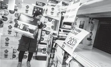  ?? BEBETO MATTHEWS/AP ?? A shopper carries a crockpot during Target’s Black Friday sale last year in New York City, The National Retail Federation, the nation’s largest retail group, delayed the release of its holiday sales forecast by about a month, citing the uncertaint­y around the pandemic.