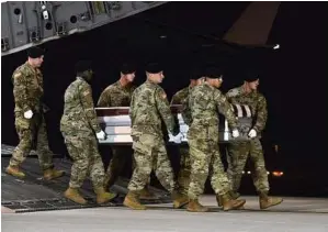  ??  ?? Staff Sgt. Aaron J. Jenne /U.S. Air Force via AP A U.S. Army team transfers the remains of Army Staff Sgt. Dustin Wright of Lyons, Ga., on Thursday upon arrival at Dover Air Force Base, Del. Wright, 29, was one of four U.S. troops and four Niger forces killed in an ambush by dozens of Islamic extremists.