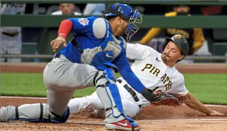  ?? Matt Freed/Post-Gazette ?? Bryan Reynolds scores ahead of the tag by Cubs catcher Wilson Contreras Saturday in the Pirates seven-run second inning.