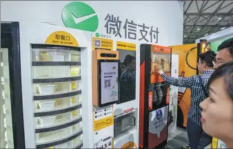  ?? PROVIDED TO CHINA DAILY ?? Visitors try out vending machines using Tencent’s WeChat app during an industry expo in Shanghai.