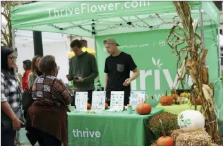  ?? SUBMITTED PHOTO ?? Thrive Flower co-founders Curt Matthias, left, and Colby Mills speak to customers at a fall market.