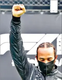  ?? POOL/AFP ?? Hamilton raised his fist on the podium to support global protests of racial oppression.