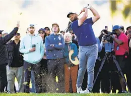  ?? RYAN KANG AP ?? Jon Rahm, who shot a bogey-free 65, hits his second shot on the par-5 17th during the third round of the Genesis Invitation­al at Riviera on Saturday.