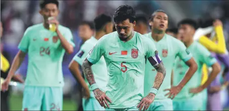  ?? XINHUA ?? A dejected Zhang Linpeng and his Team China players take stock after losing their last Asian Cup group match to Qatar on Monday.