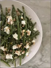  ?? PHOTO BY CATHY THOMAS ?? Green beans with citrusy vinaigrett­e, coarsely chopped almonds and crumbled goat cheese can either be a side dish to your Easter ham or stand alone as a vegetarian main course.