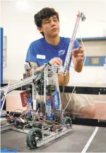  ??  ?? Trevor Salom, 17, of San Jose, gets his Bellarmine College Preparator­y team’s robot ready for competitio­n on opening day of the Santa Clara County Fair.