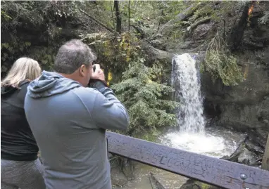  ?? PATRICK TEHAN/STAFF ?? Kimberly McDaniels, of Santa Clara, and her father, Tom Hielscher, of Hudson, Florida, enjoy the deluge at Sempervire­ns Falls at Big Basin Redwoods State Park in Boulder Creek. Recent storms have replenishe­d local reservoirs.