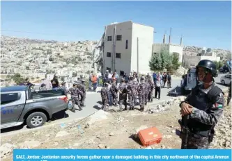  ??  ?? SALT, Jordan: Jordanian security forces gather near a damaged building in this city northwest of the capital Amman yesterday. —AFP